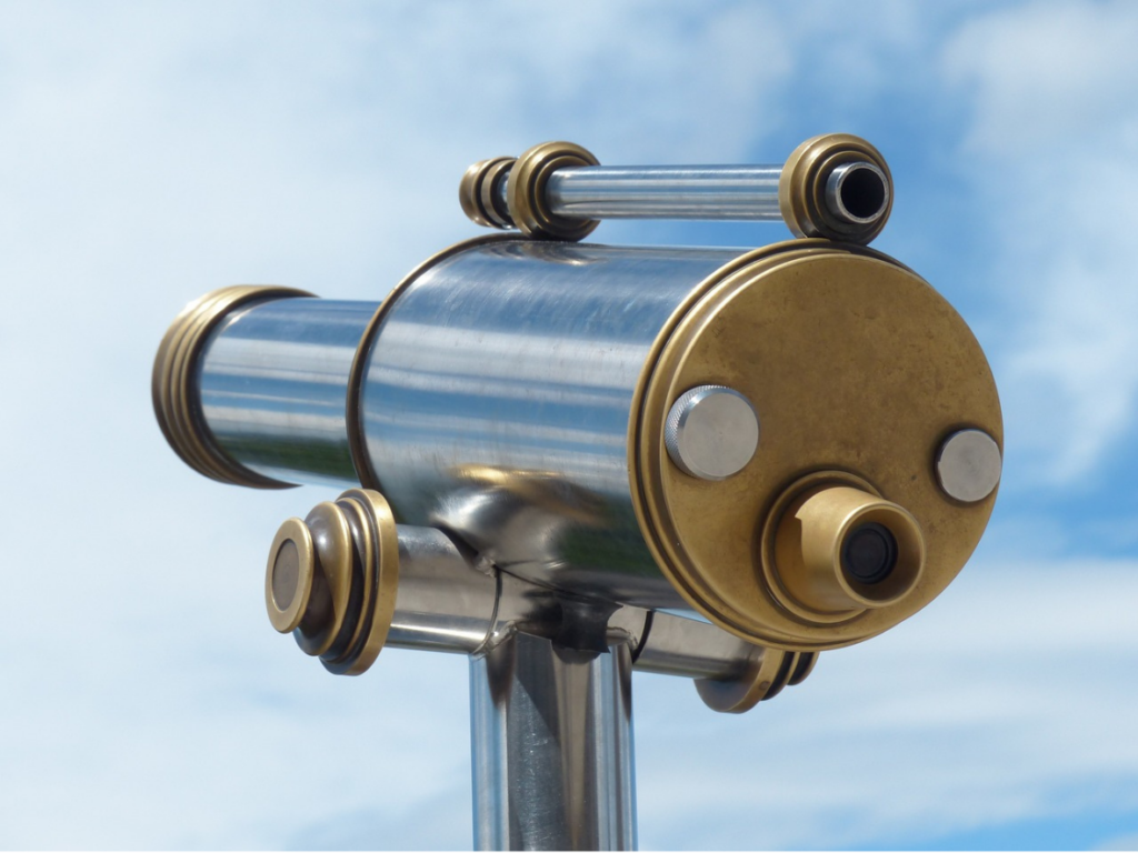 A telescope on a pole with a blue sky background.