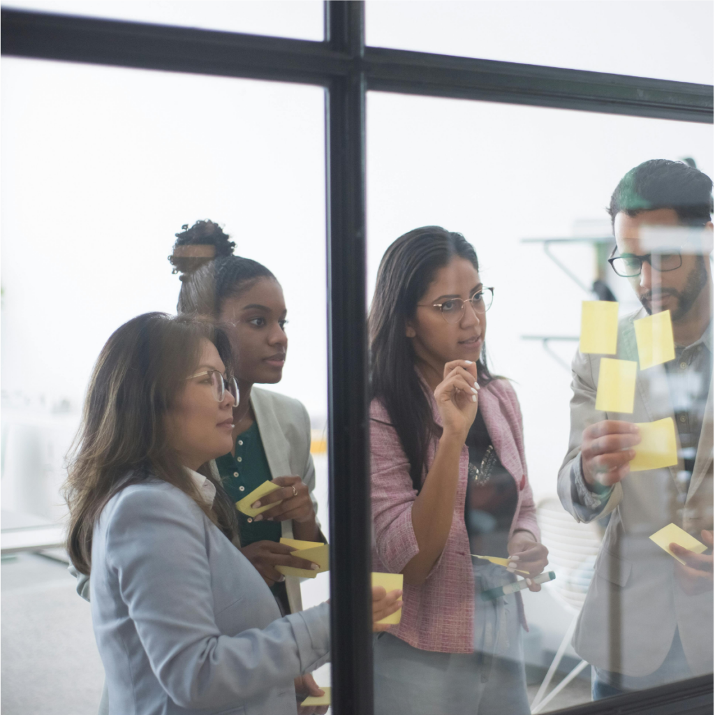 A group of business people standing in front of a window during a professional training session.