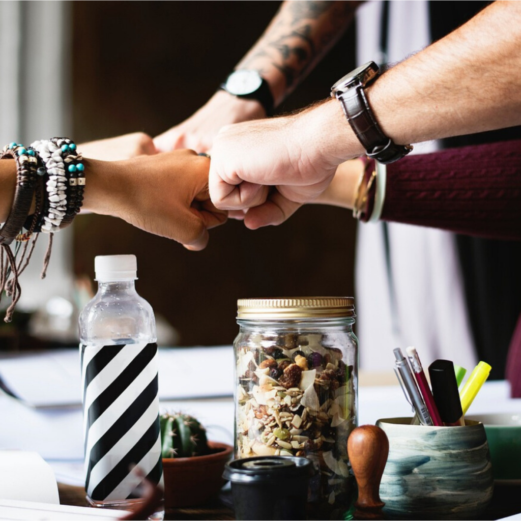 A group of people holding hands on a table.