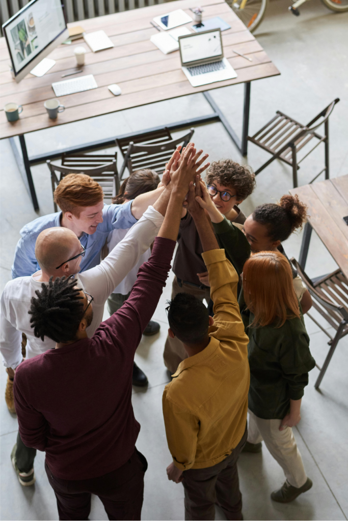 A group of people giving each other high fives in an office.