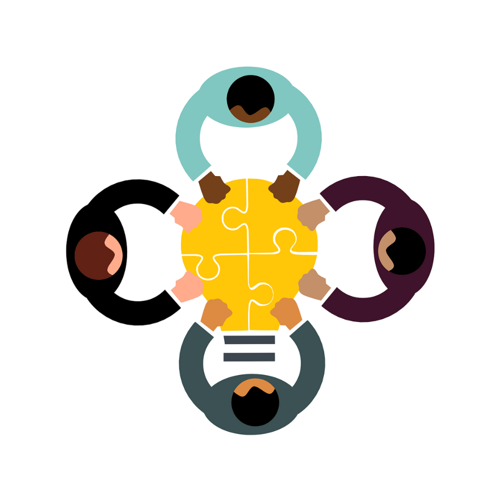 Quatre personnes sont assises à une table, chacune tenant une pièce d'un casse-tête jaune, symbolisant le travail d'équipe et la collaboration essentiels à la qualité de vie au travail.